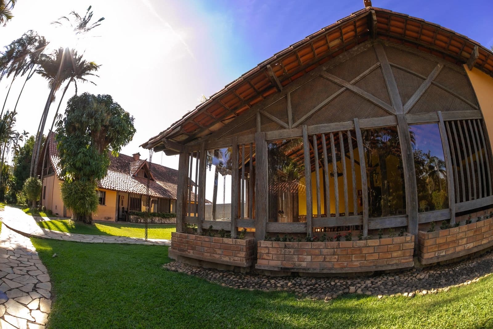 Construção de madeira e vidro do sítio, com estrutura aparente e telhado de telha