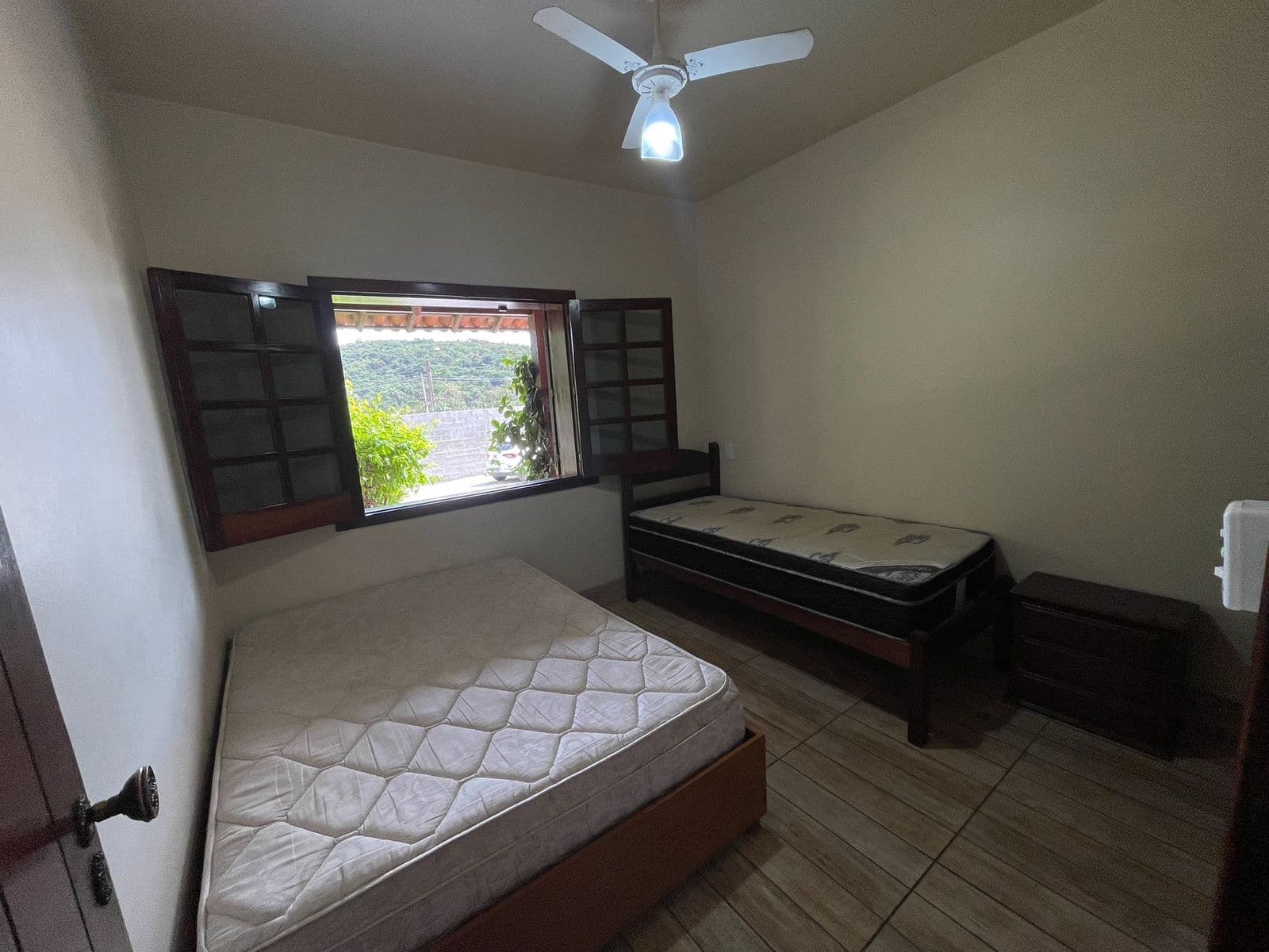 Quarto 2, com cama de casal, cama de solteiro e janela de madeira