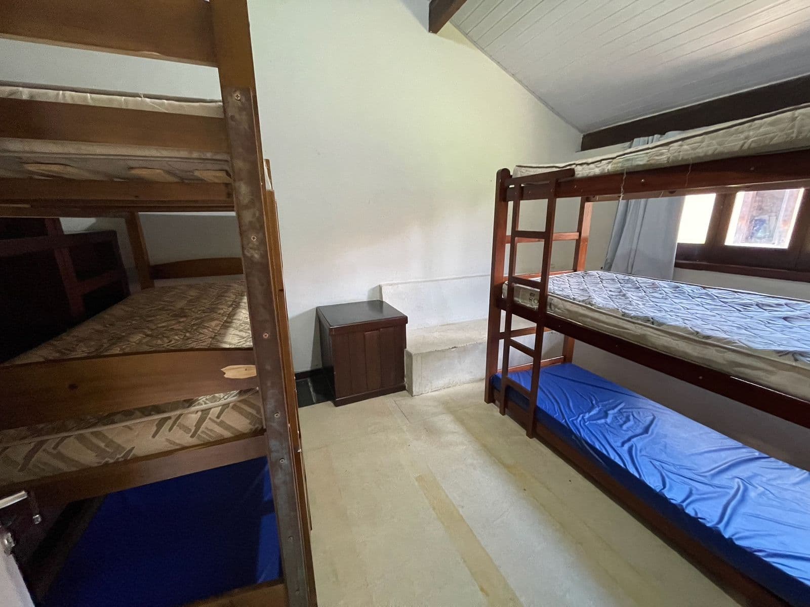 Quarto 4, com dois triliches de madeira e teto alto