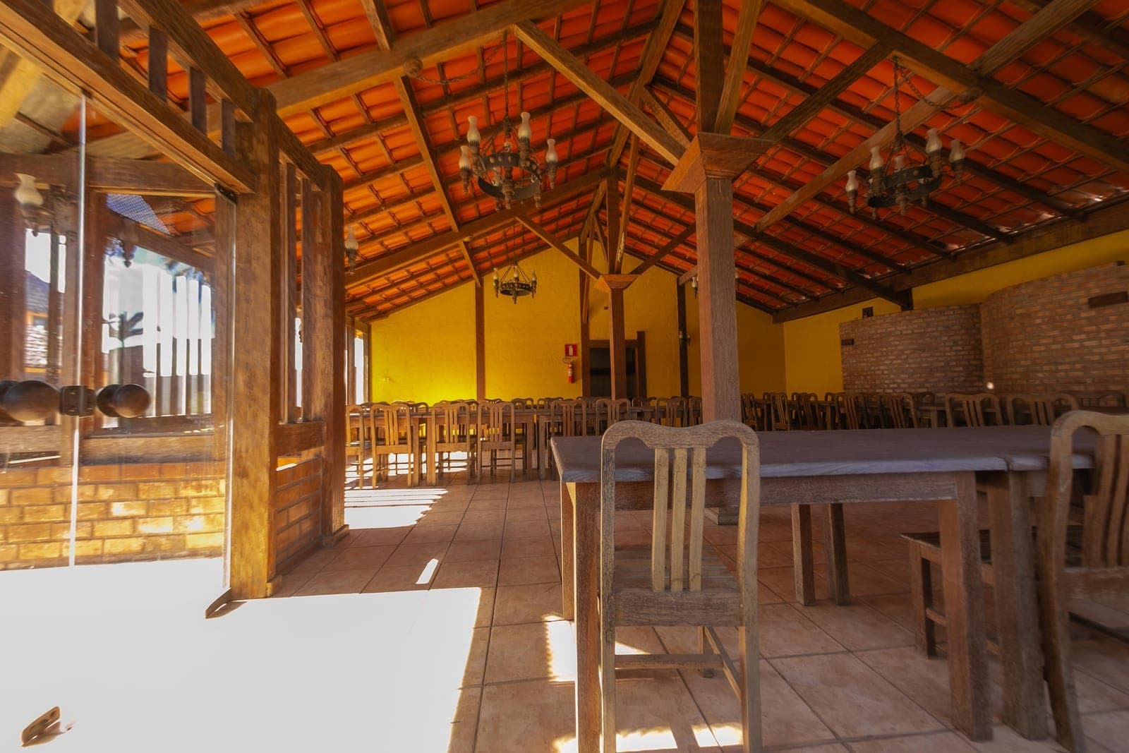 Salão de festas coberto, com mesas e cadeiras montadas para receber convidados